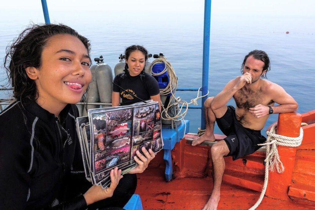 Dive instructor briefing a small group on a boat