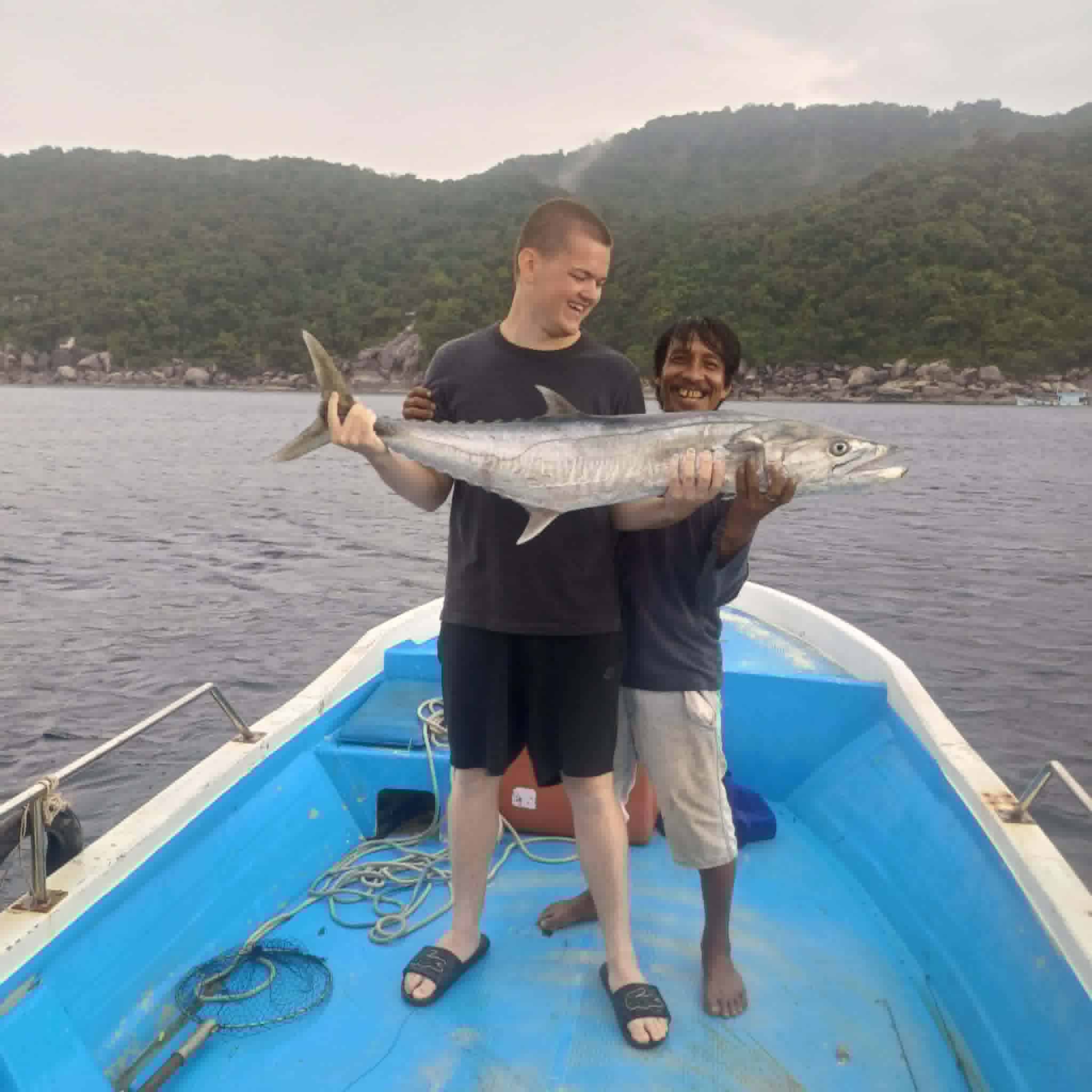 Guest holding a barracuda after a Koh Tao fishing trip