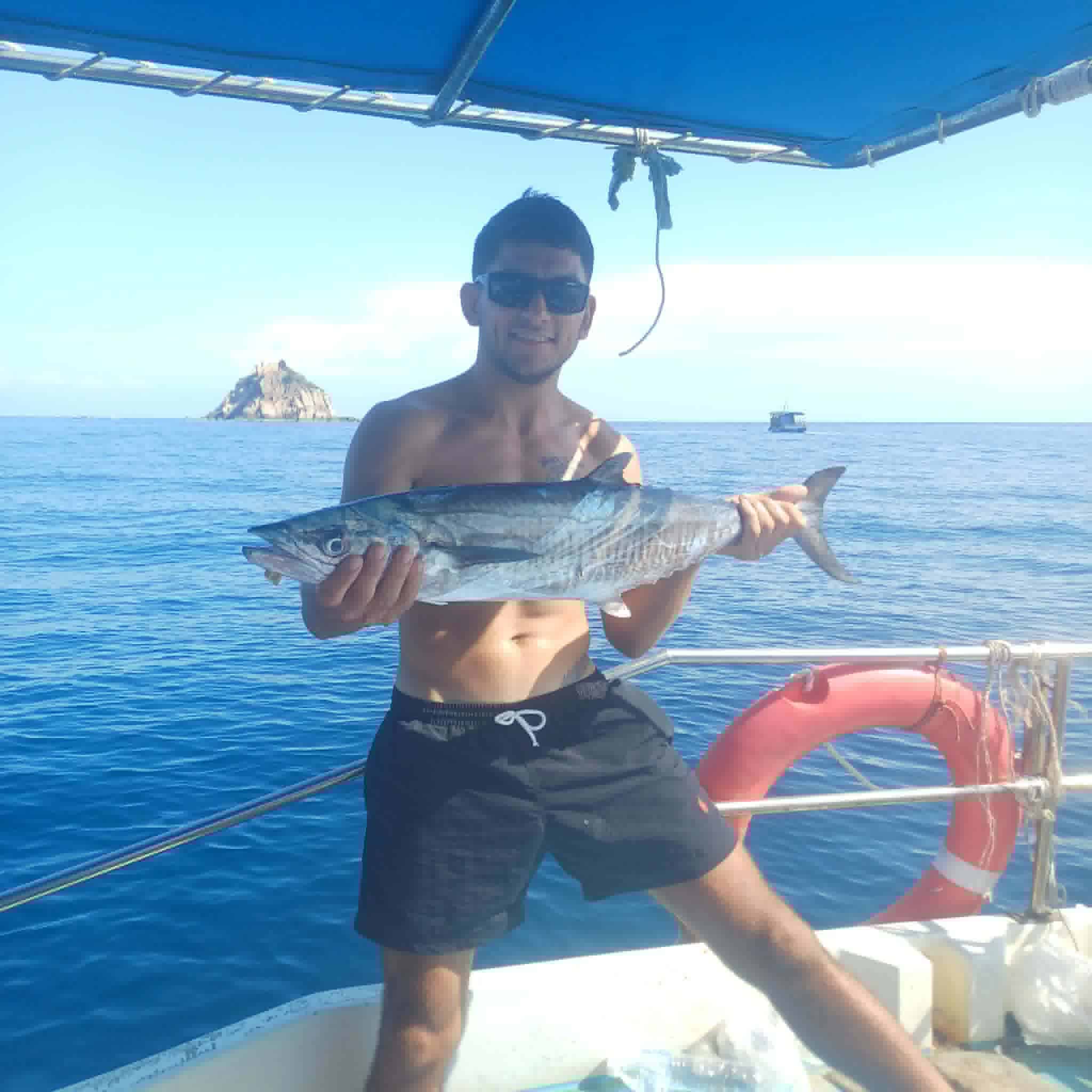 Guest holding a fish on a Koh Tao fishing boat