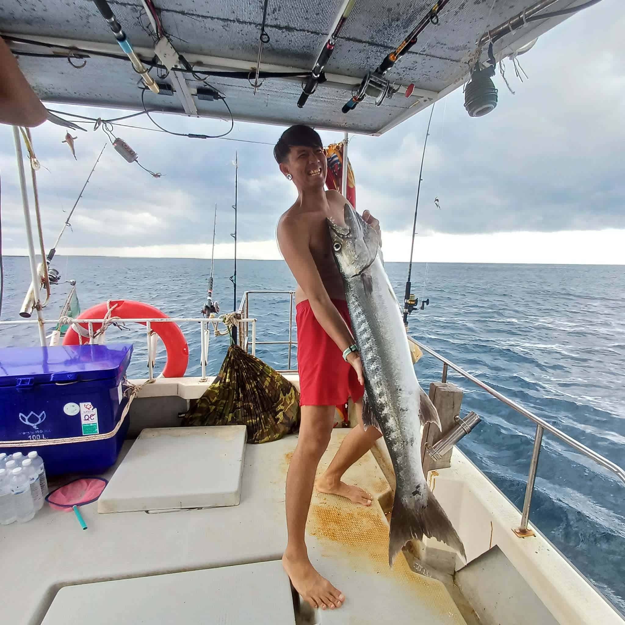 Guest holding a large barracuda on a Koh Tao fishing trip