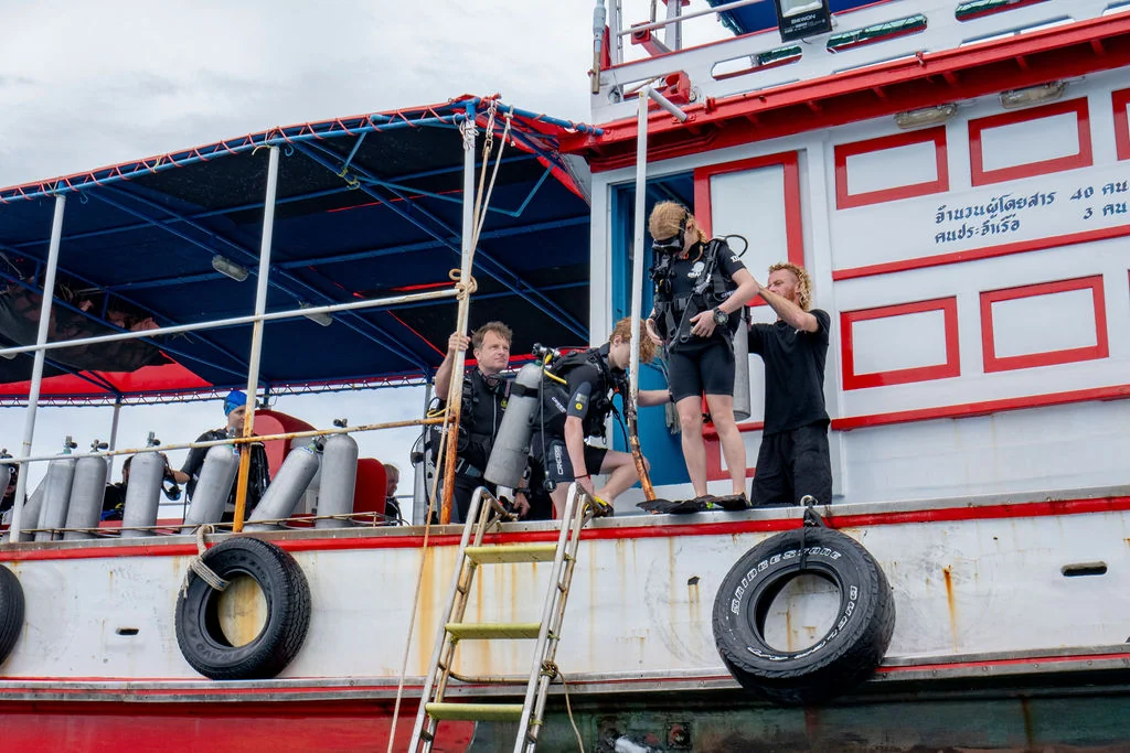 Divers preparing to enter the water from a dive boat